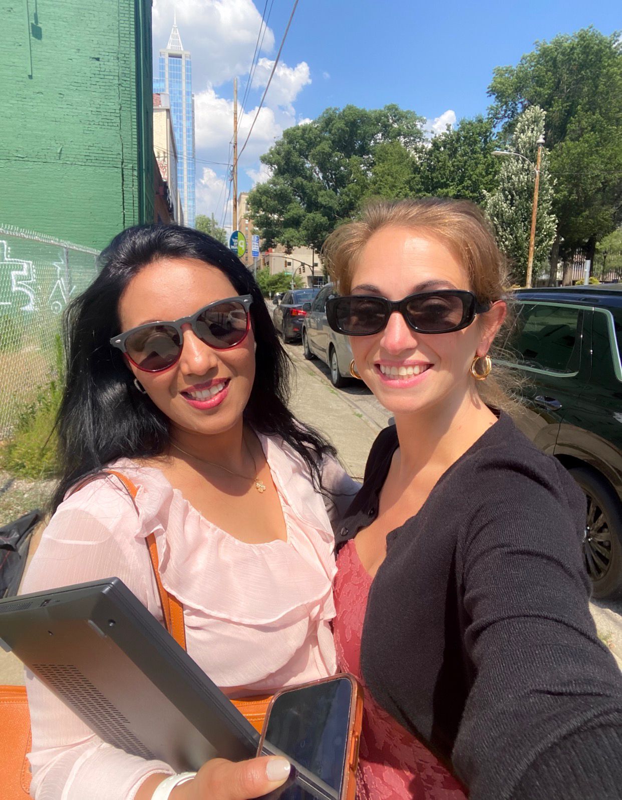 Three women taking a selfie outside in a city setting